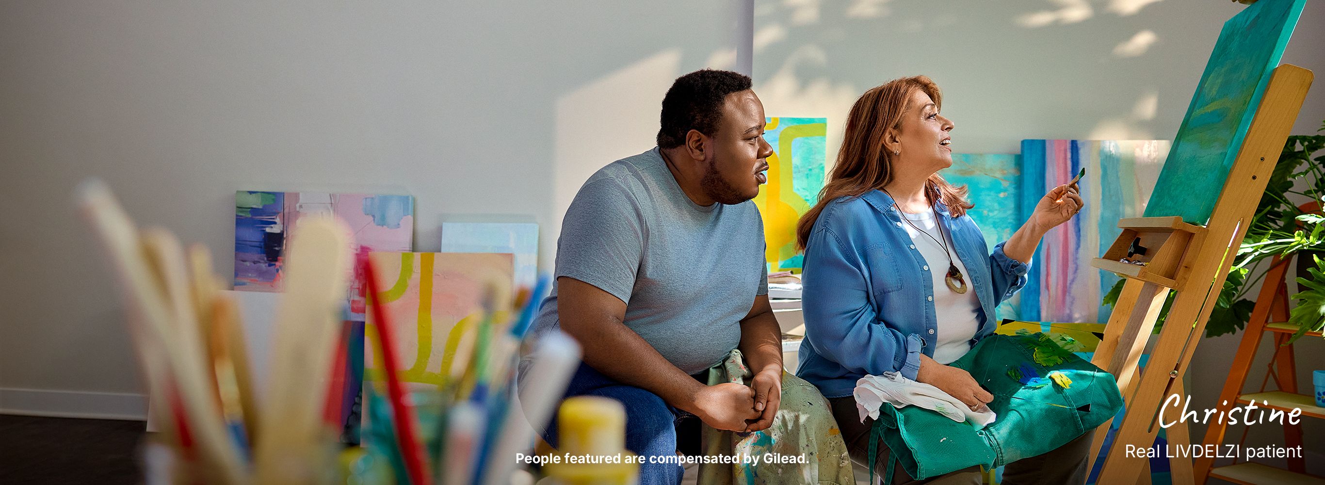 Christine, a woman with PBC, and her son painting in an art studio